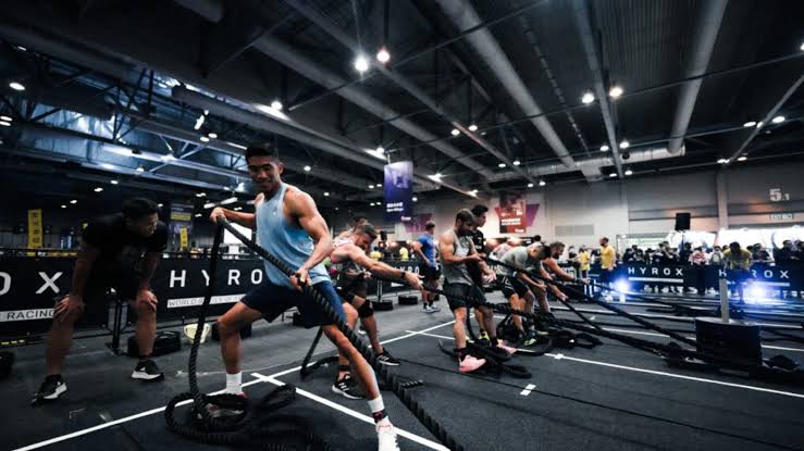 HYROX athletes training with battle ropes
